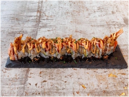 Exclusieve Rollen (8 stuks)  Vulling: gefrituurde garnaal, avocado.   Topping: geflambeerde zalm, unagi saus, sriracha mayonaise, gebakken uitjes, bieslook. 